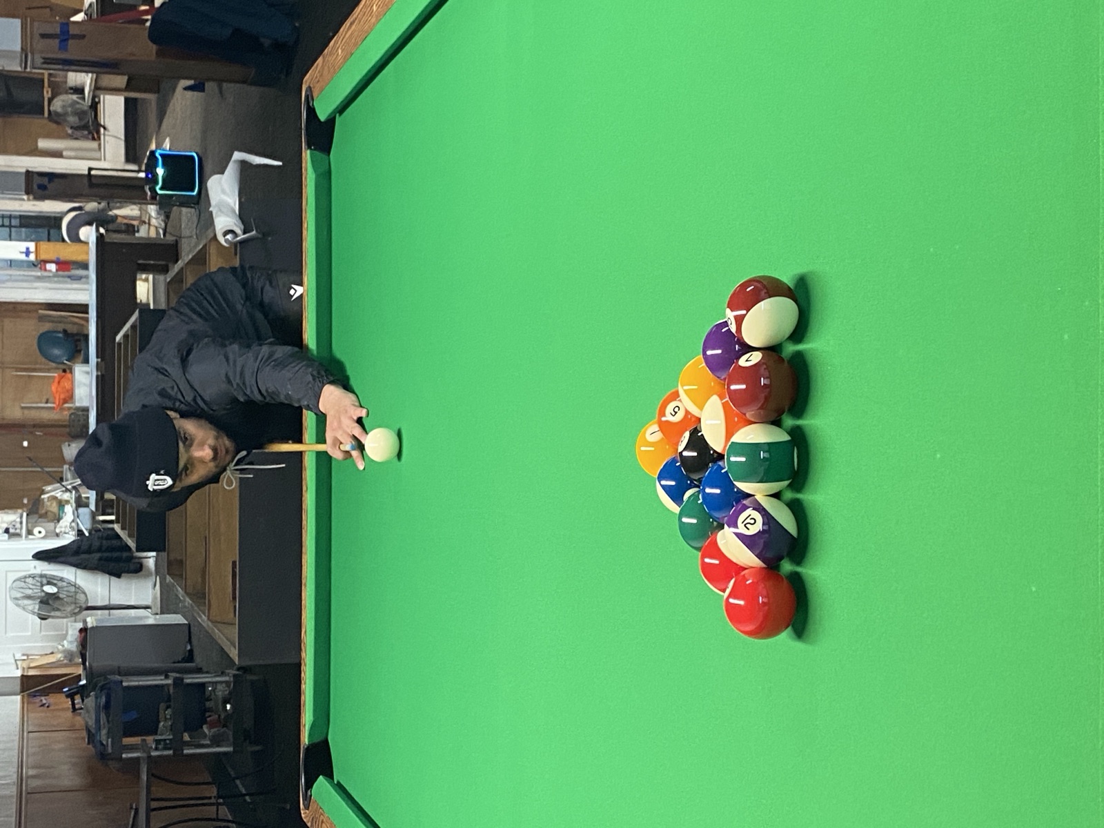 A player breaking a fresh rack on green felt