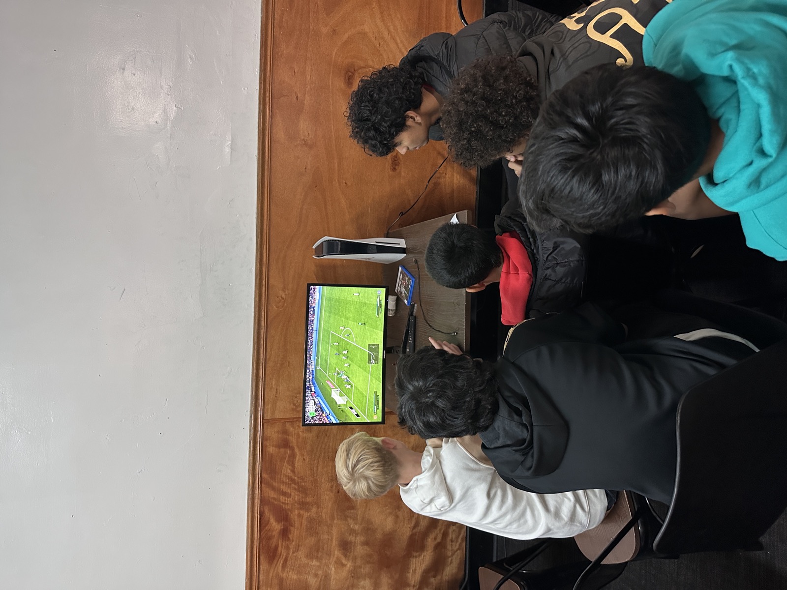 Friends gathered around a game console at 23rd Billiards