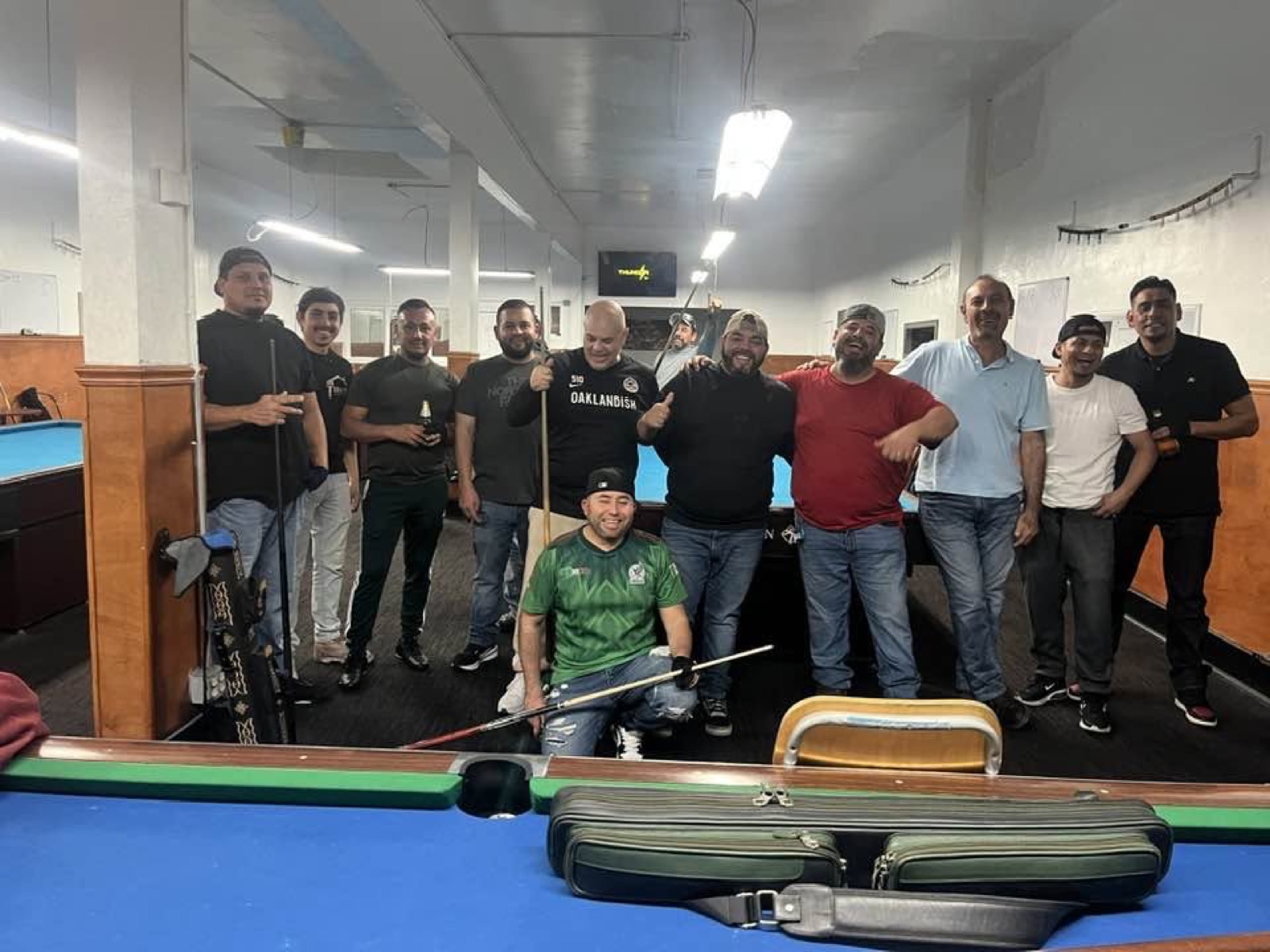 Group of friends posing with cues at 23rd Billiards